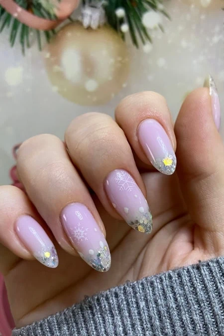 Elegant winter-themed nail art with snowflake designs and glitter accents
