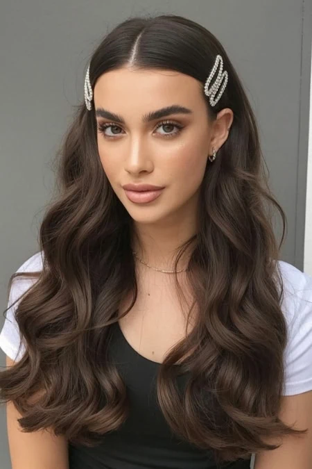 young woman with long dark hair and rhinestone clips on each side