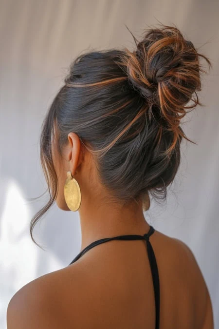 Beautiful woman with messy bun hairstyle and gold earrings, stylish and elegant hairdo, perfect for beauty, hair, and fashion inspiration