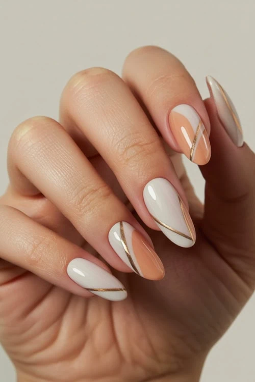 Elegant almond-shaped nails with white, nude, and gold accents showcasing modern nail art design for a chic beauty look.