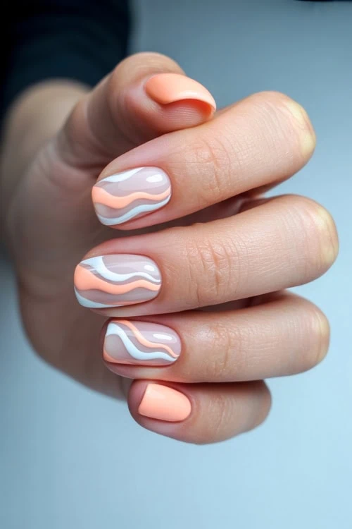 Vibrant peach and white marbled gel nails with smooth, glossy finish for a chic and trendy manicure.