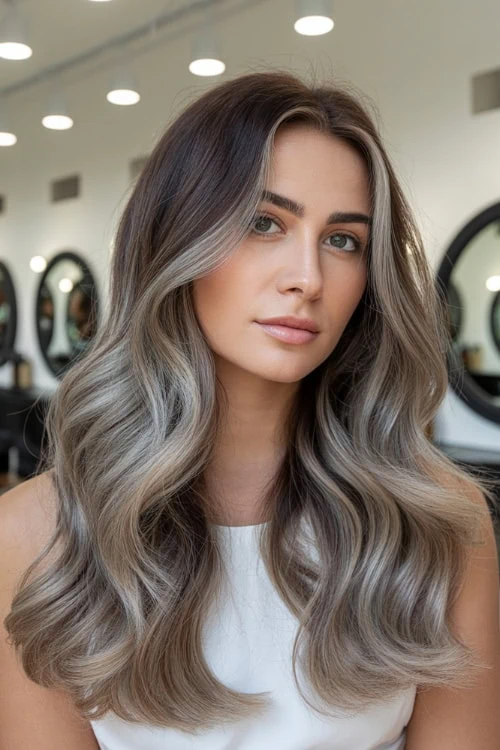 Long balayage hairstyle with soft waves and natural highlights for fall.