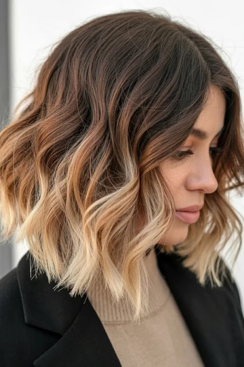 Blonde balayage shoulder-length wavy hairstyle for a trendy and natural look. Perfect for women seeking stylish hair color and textured waves.
