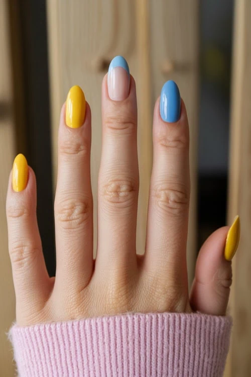 Vibrant yellow and blue nail polish on manicured fingernails, close-up of colorful nail art design, perfect for beauty and fashion inspiration.