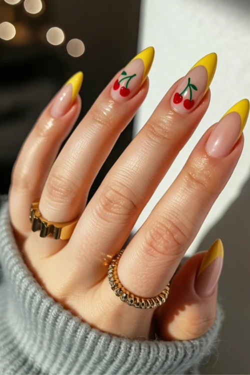 Bright yellow French manicure with cherry nail art on natural nails, fashionable nail design, perfect for summer, trendy manicures, and nail art inspiration.