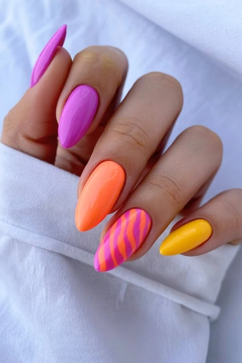 Bright neon multicolor acrylic nail manicure with pink, orange, and yellow gel polish, trendy bold nail art for summer or special occasions.