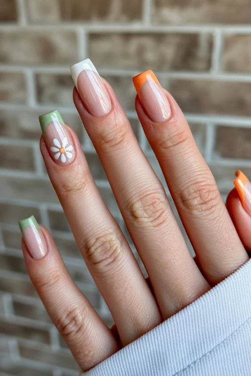 Colorful spring nail art with floral accent on natural french tip nails, perfect for beauty and manicure inspiration.