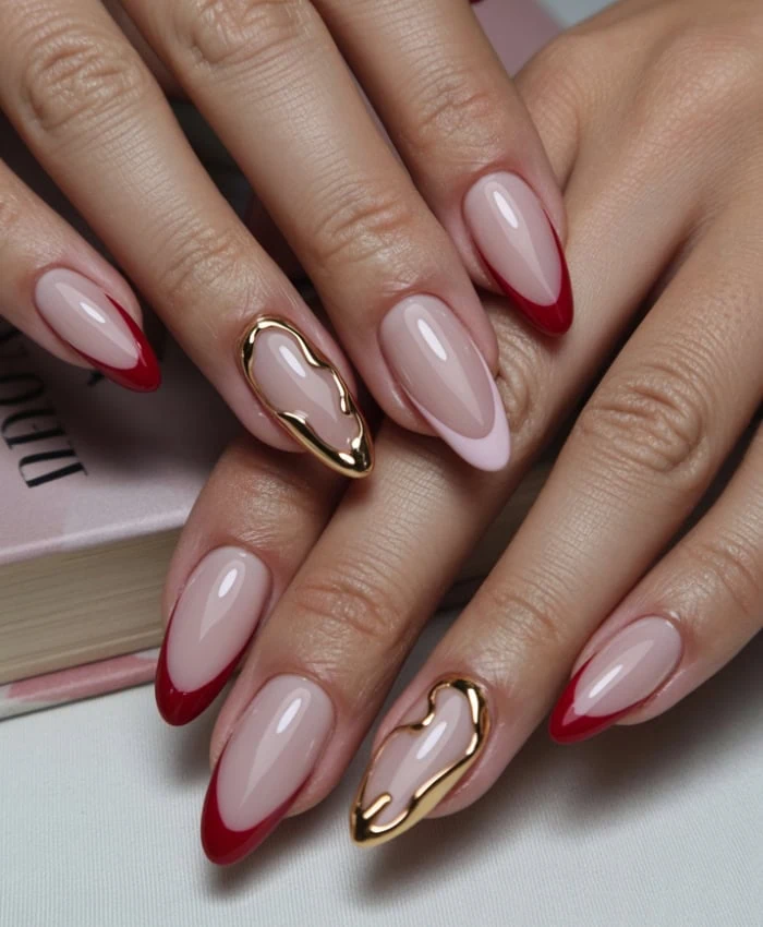 Elegant almond-shaped nails featuring a classic red French tip design with gold heart-shaped accents, perfect for beauty and nail art inspiration.