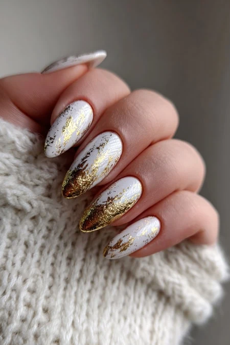 Golden and white marble nails with a glossy finish, perfect for luxury beauty and winter manicures.