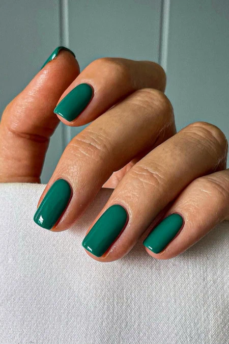 Vibrant green manicure on well-maintained fingers.