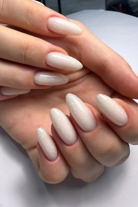 Elegant white glitter ombre coffin-shaped gel nails with a smooth finish, perfect for a sophisticated manicure look. Ideal for special winter occasions or stylish everyday wear, showcasing professional nail art.