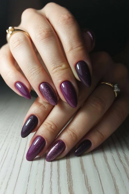 Elegant purple and glitter manicure with well-manicured nails on female hands relaxing on a white wooden surface.