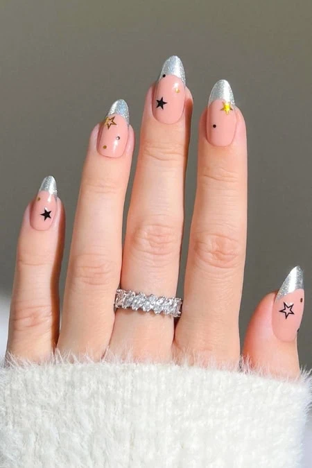 Delicate nail art featuring glittery silver tips and star-shaped accents on natural nails, perfect for enhancing beauty and style.