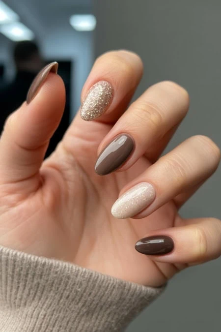 Cream and glitter nude and taupe gel manicured nails showcasing perfect nail art and healthy nails at The Beauty Deep Life.