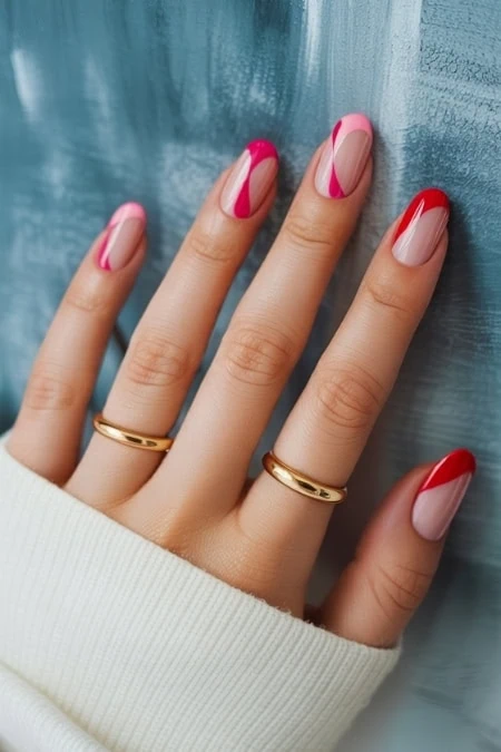 Vibrant pink and red nail art featuring geometric design on well-manicured nails with gold rings, perfect for trendy beauty and nail art enthusiasts.