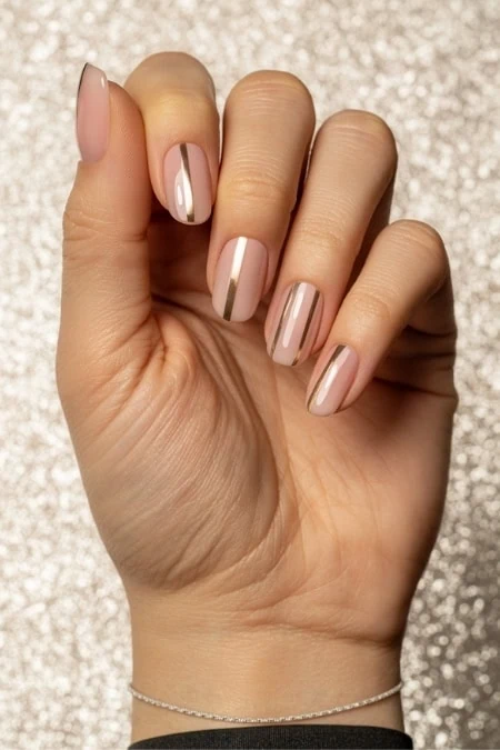 Elegant nude gel manicure with gold accent nail, perfectly glossy and well-maintained, suitable for beauty and nail care enthusiasts.