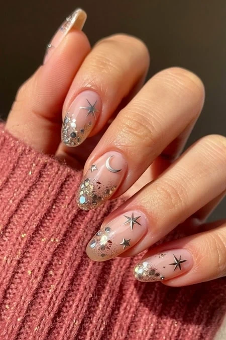 Sparkly celestial nail art with stars, moons, and glitter for festive or holiday celebrations like new years. Perfect for women who love glamorous, space-inspired nail designs with a touch of shimmer.