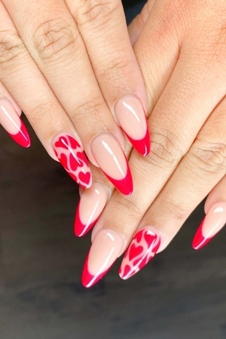 Bright red heart-themed Valentine's Day nail art with almond-shaped acrylic nails, perfect for romantic occasions and enhancing beauty and self-care routines.