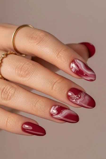 Elegant red and white marbled acrylic nail design with gold embellishments, perfect for a stylish and sophisticated look.