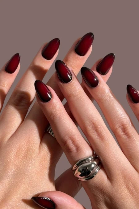 Dark red ombre gel nail polish with long, almond-shaped nails, perfect for elegant and bold botox nails, manicures, and stylish nail art.