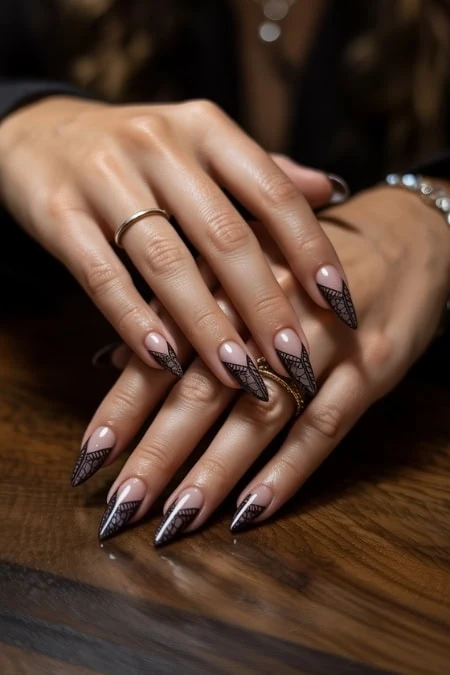 Elegant manicured nails with intricate black lace nail art design, showcasing professional nail artistry and beauty salon manicure services.