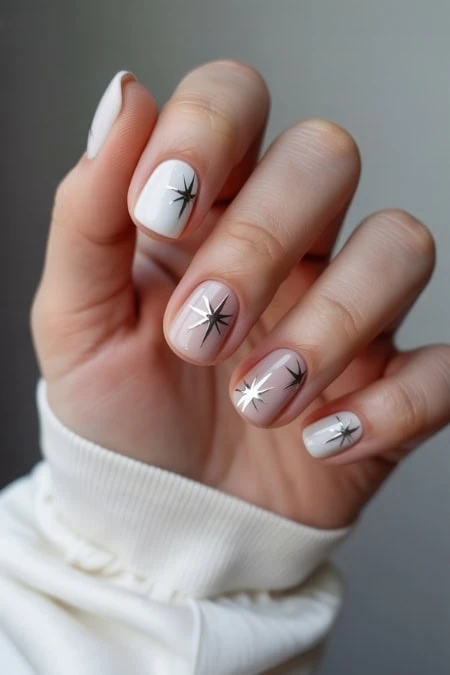 Minimalist white nail art with starburst design, perfect for stylish and modern manicure looks.