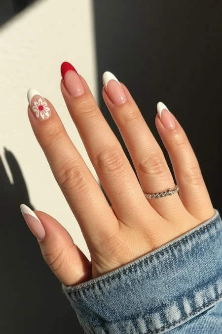 Beautiful manicured nails with floral design, French tips, and natural look, featuring a delicate ring, perfect for nail art enthusiasts and trendy fashion statements.