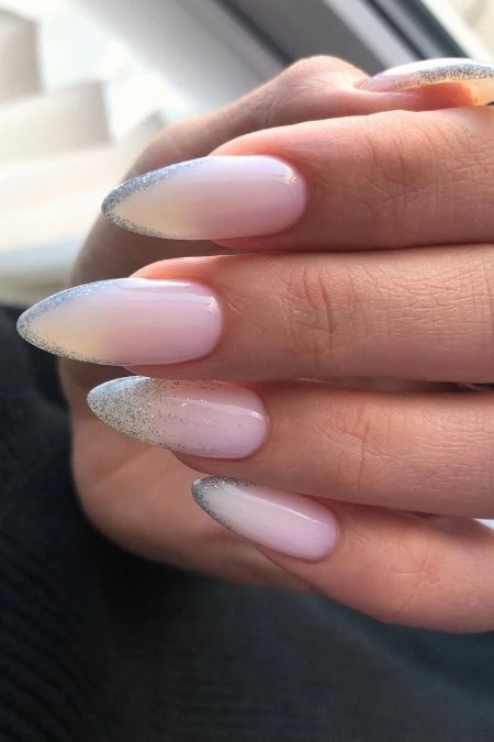 Elegant French ombré nails with glittery silver tips for a sophisticated and trendy look. Perfect for special occasions or everyday chic, showcasing flawless manicure styling.