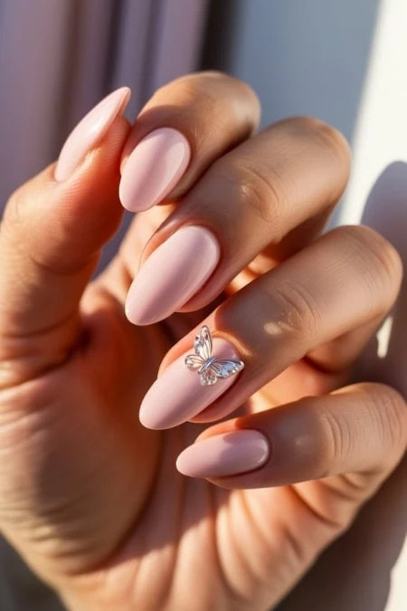 Elegant nude almond-shaped manicure with a 3Dembellishment, perfect for a sophisticated beauty look.