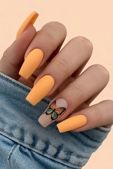 Elegant butterfly nail art with pastel purple and peach tones on almond-shaped nails, featuring detailed butterfly designs for a trendy and delicate look.