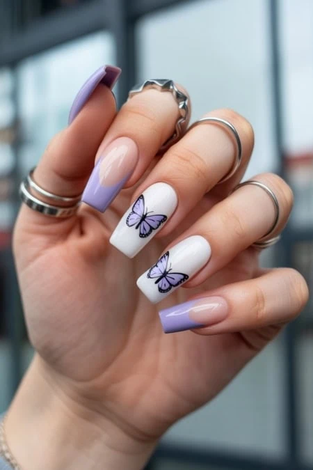 Elegant butterfly nail art with pastel purple and peach tones on almond-shaped nails, featuring detailed butterfly designs for a trendy and delicate look.