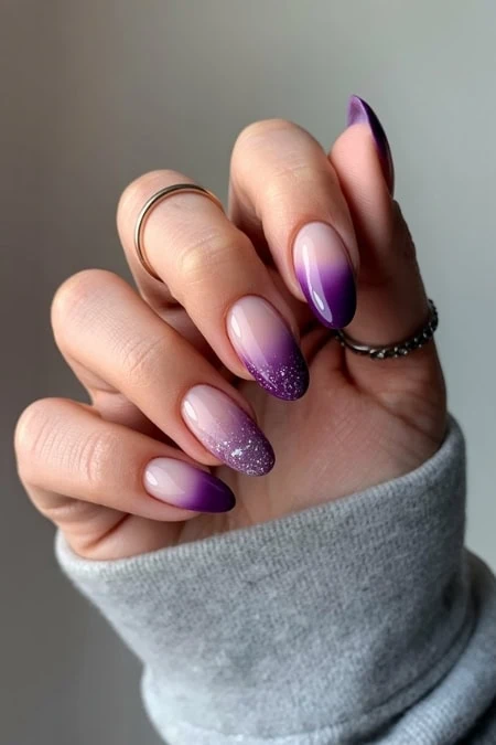 Violet and glitter ombre acrylic nails with almond shape, modern nail art design, perfect for beauty and fashion enthusiasts.