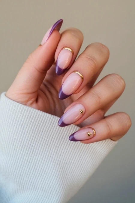 Elegant almond-shaped nails with purple French tips and star nail art, featuring gold accents and glossy finish, perfect for a chic and trendy beauty look.