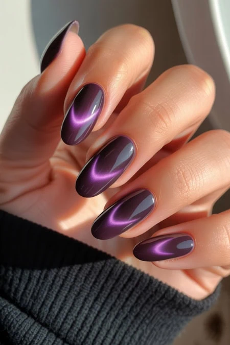 Vibrant purple and black ombre nail art with glossy finish, perfect for trendy beauty and manicure styles, shown on well-groomed feminine hand.