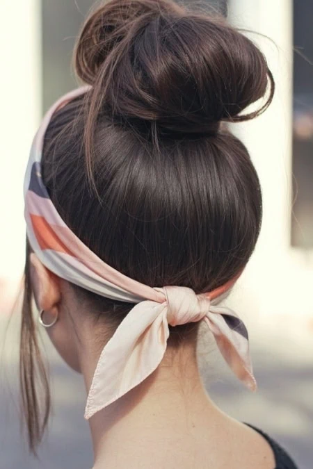 Elegant updo hairstyle with a chic silk scarf headband, perfect for beauty and hair styling inspiration.