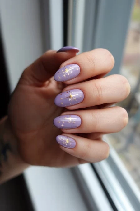 Violet galaxy-inspired nail art with gold constellation designs, perfect for a stylish and trendy look. Manicure showcases celestial-themed nail art on a beautifully painted nails.