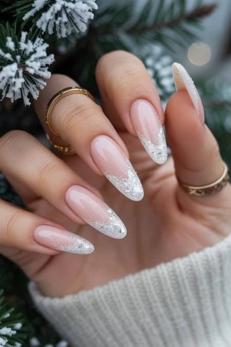 Elegant Christmas-themed nail art with glittery silver tips and a clear glossy finish, showcasing perfect manicure for holiday celebrations and special occasions.