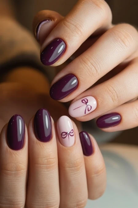 Elegant purple and pink nail polish with bow accent nails, perfect for holiday or special occasion manicures. Professional gel or acrylic nails featuring a glossy finish and stylish design.