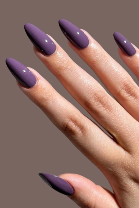 Violet matte acrylic nail manicure on well-manicured fingers, perfect for beauty and nail art creativity, showcasing trendy nail design and professional nail polish application.