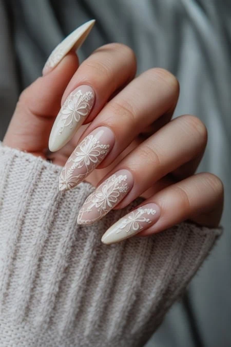 Elegant bridal nail art with white floral lace design on long almond-shaped nails, perfect for wedding and special occasions. Expertly crafted for a refined and stylish look.
