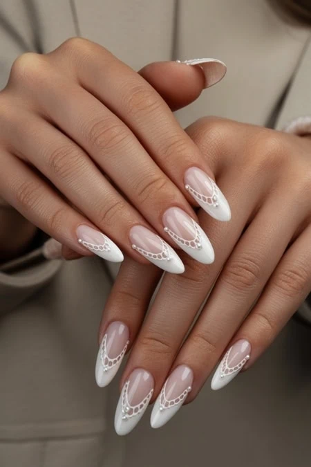Elegant white French manicure with intricate lace details on almond-shaped nails, perfect for a sophisticated look, nail art, and professional beauty enhancements.