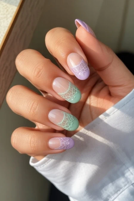 Colorful pastel ombre Halloween-inspired nail art with lace designs on almond-shaped nails, perfect for beauty and nail art enthusiasts.
