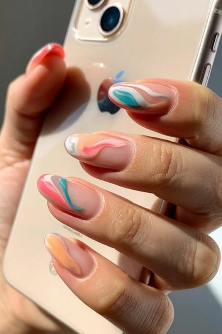 Vibrant swirl acrylic nail art with colorful pastel marbling design on well-manicured nails, holding a smartphone. Perfect for beauty, manicure, and nail art inspiration.