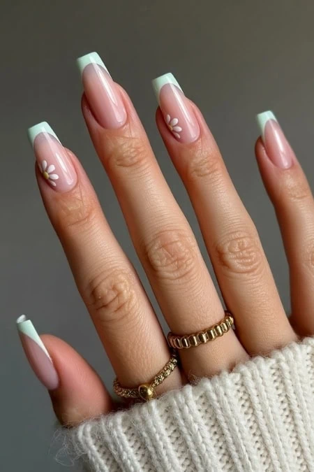 Elegant French manicure with floral accent nails, perfect for beauty and nail art enthusiasts, showcasing a sleek and stylish look.