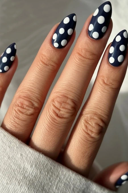Stylish navy blue polka dot nail art on well-manicured fingers for a chic, trendy look. Perfect for summer or special occasions, showcasing professional gel nail designs and creative nail art ideas.