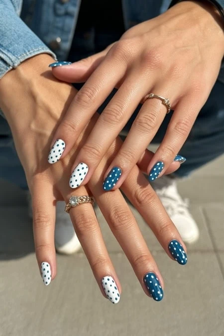Polished nails with white and blue polka dot design, trendy manicure, perfect for spring or summer, showcasing stylish nail art and skincare beauty trends.