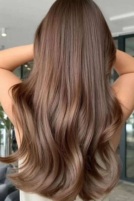 High-quality brunette hair with soft waves, healthy and glossy, showcasing expert hair coloring and styling. Perfect for beauty and haircare SEO optimization.