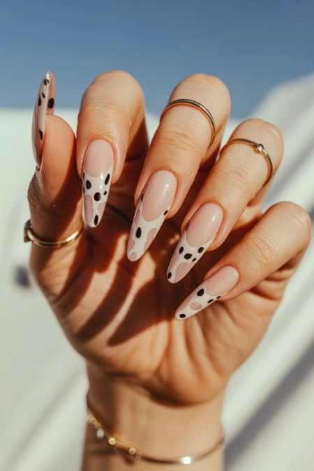 Elegant almond-shaped nails with stylish Dalmatian animal print design, trendy manicure, modern nail art, perfect for fashion-forward beauty looks.