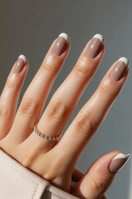 Elegant beige and white French manicure on well-groomed hand with dainty diamond ring, perfect for beauty, nails, and fashion enthusiasts seeking stylish manicure inspiration.