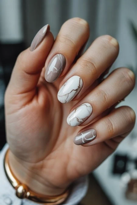 Elegant marble nail art manicure featuring neutral beige and white tones with gold accents, perfect for a sophisticated look. Crafted for modern beauty, ideal for professional salons and personal style.